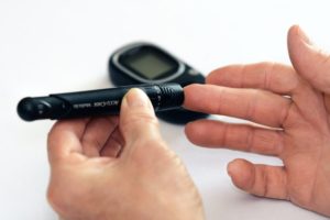 A man testing his blood sugal level with a testing kit